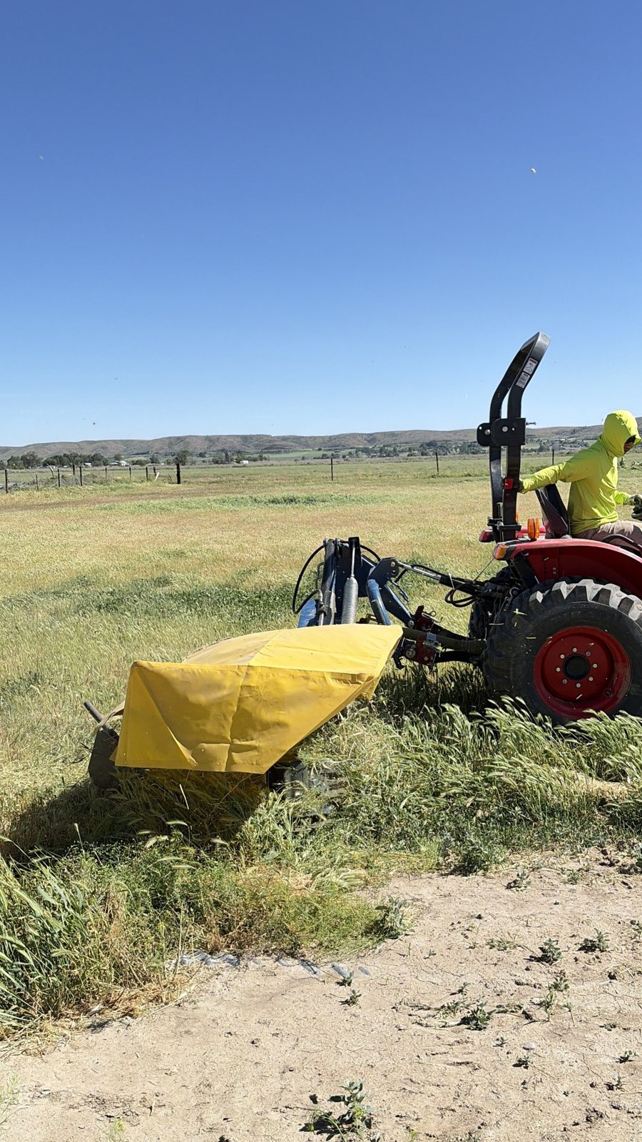 Cutting hay with a red tractor and disc mower