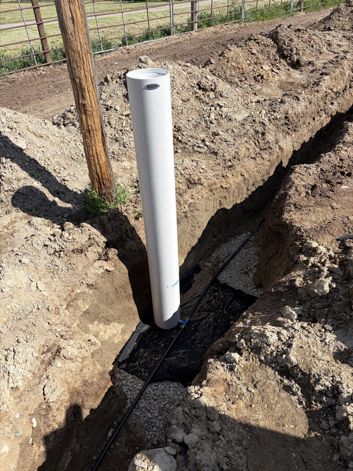 An automatic waterer installed over gravel and landscape fabric