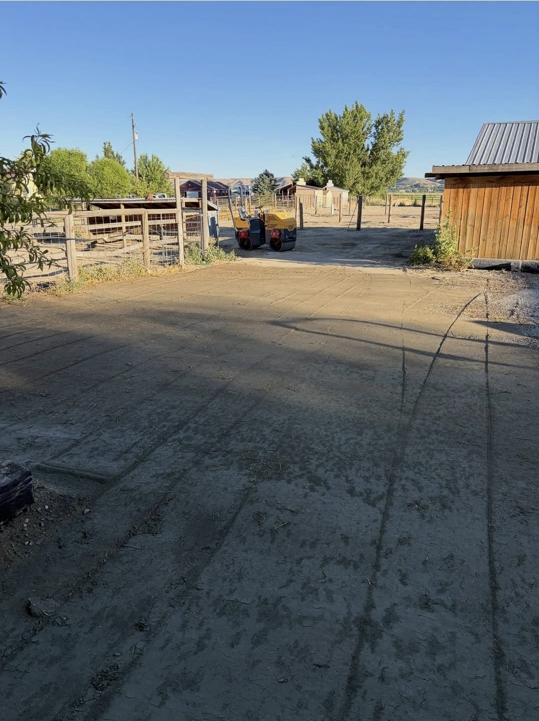 A freshly rolled yard between the barn and the corrals